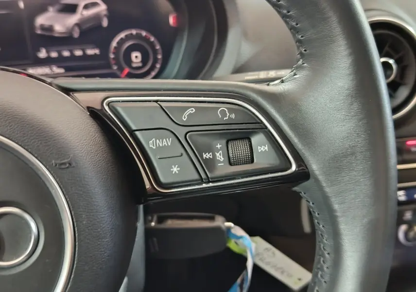 Gros plan sur les commandes multifonctions du volant cuir noir de l'Audi A3 35 TDI Business Line 2020.