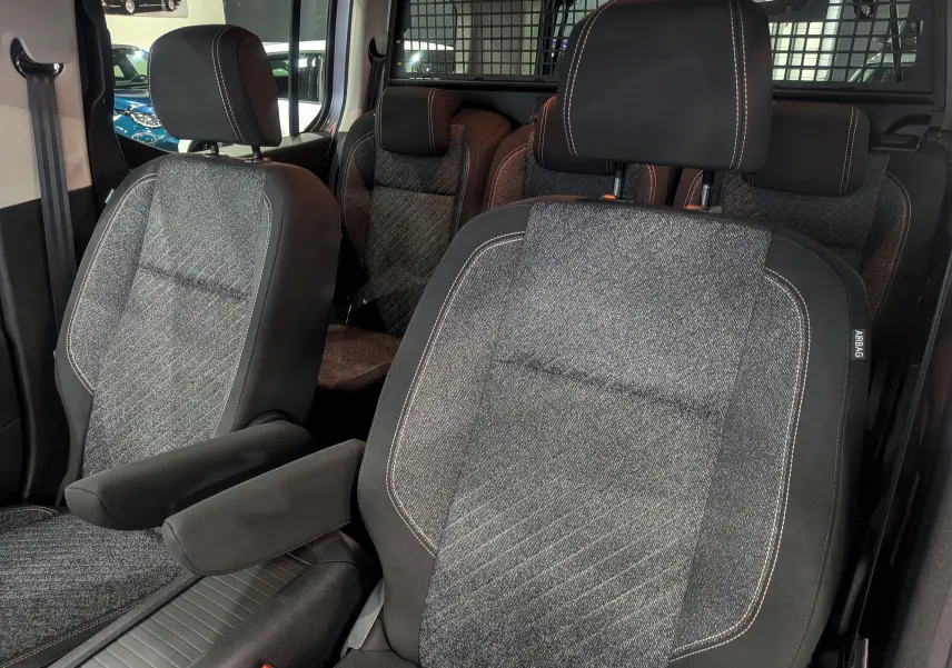 Vue intérieure rapprochée des sièges avant et arrière en tissu gris du Peugeot Rifter 2025, version Allure.