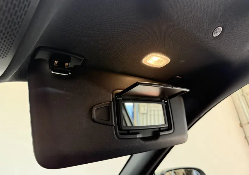 Détail du pare-soleil côté conducteur avec miroir éclairé dans l'habitacle noir du Mercedes GLA 250 e AMG Line 2023.