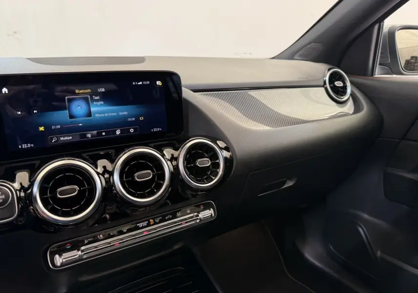 Vue intérieure côté passager du tableau de bord noir et gris clair avec écran tactile et aérateurs ronds Mercedes GLA 250 e AMG Line 2023.