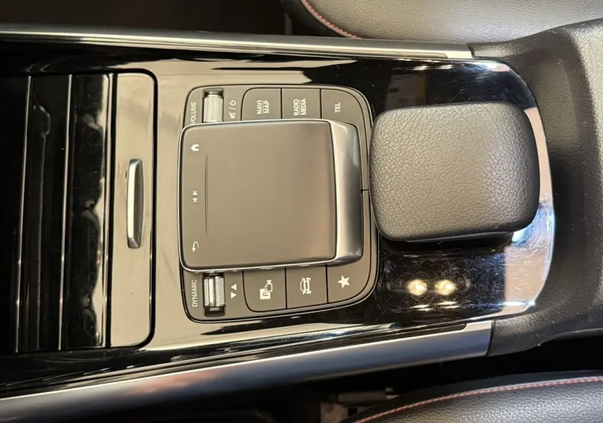 Vue rapprochée du pavé tactile central noir brillant avec commandes multimédia sur Mercedes GLA 250 e AMG Line 2023.