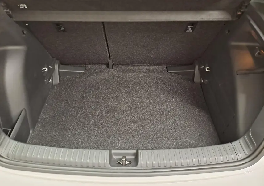 Coffre ouvert vu de l'arrière d'une Skoda Fabia 2023 blanc candy, montrant un espace de chargement propre et vide.