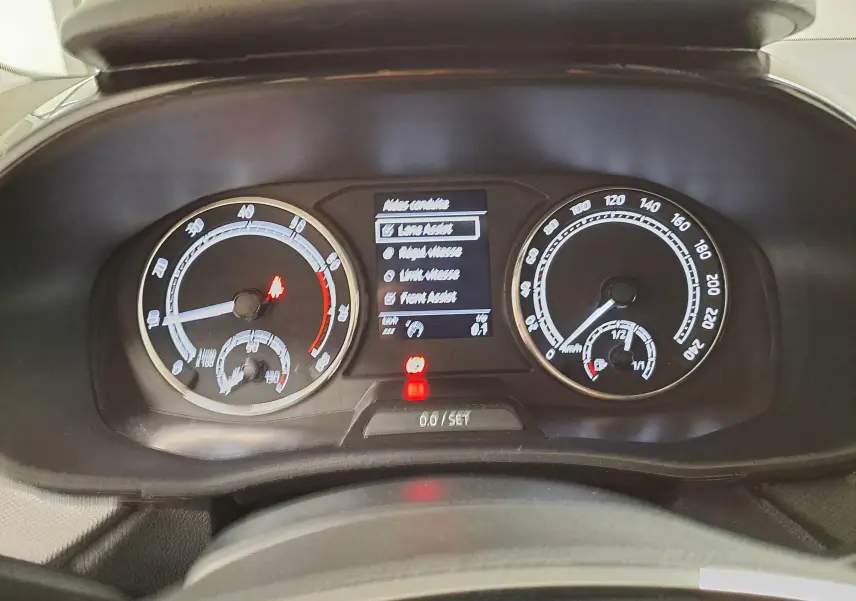 Tableau de bord de la Skoda Fabia 2023 en blanc candy, vue rapprochée sur les compteurs et l'écran central.