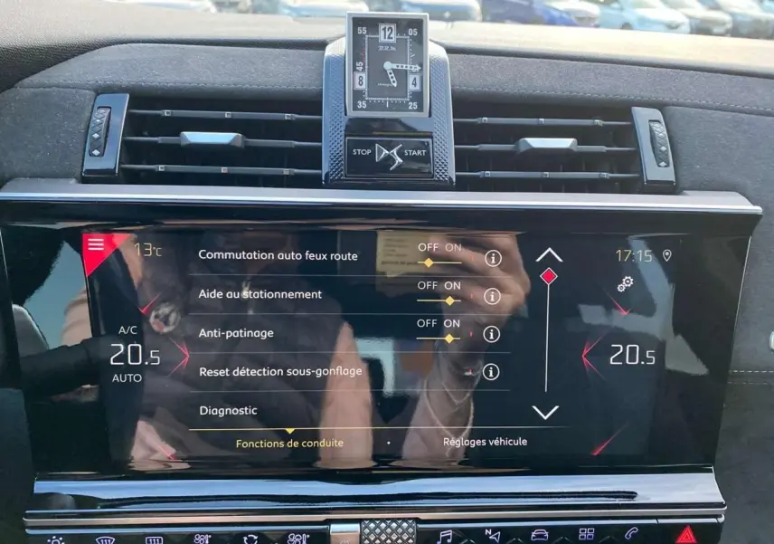 Vue rapprochée de l'écran tactile et de l'horloge digitale du tableau de bord du DS7 Crossback gris foncé.