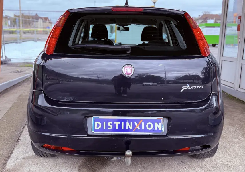Vue arrière d’une FIAT Punto noire de 2009 avec attelage et plaque d’immatriculation Distinxion visible.