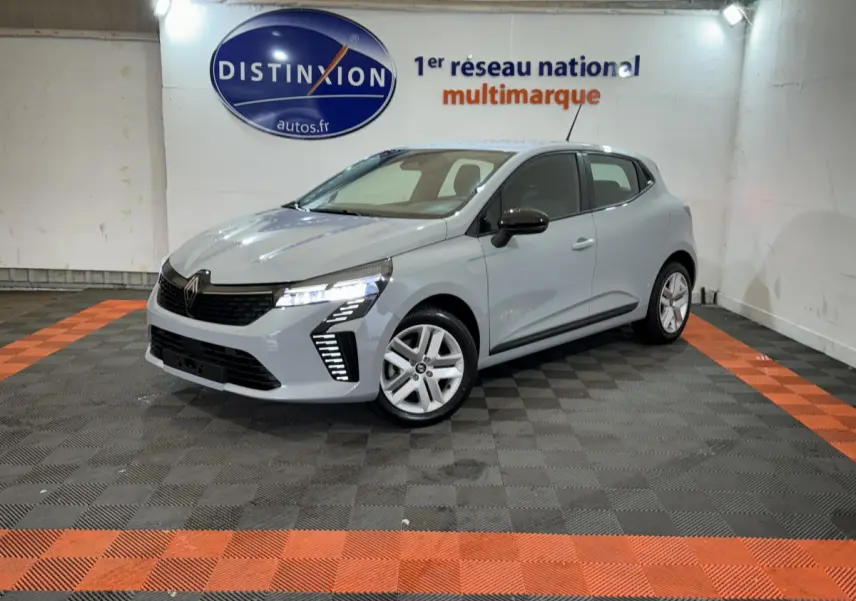 Renault Clio Evolution Blue dCi 100 gris clair vue 3/4 avant droit avec feux LED allumés en intérieur showroom.