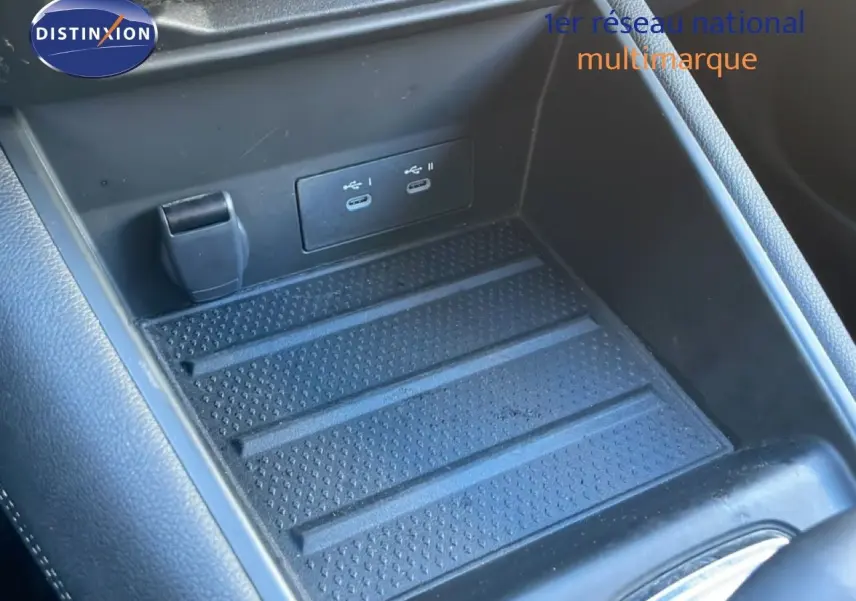 Gros plan sur la console centrale intérieure du Renault Symbioz 2025, montrant les ports USB et un espace de rangement noir.