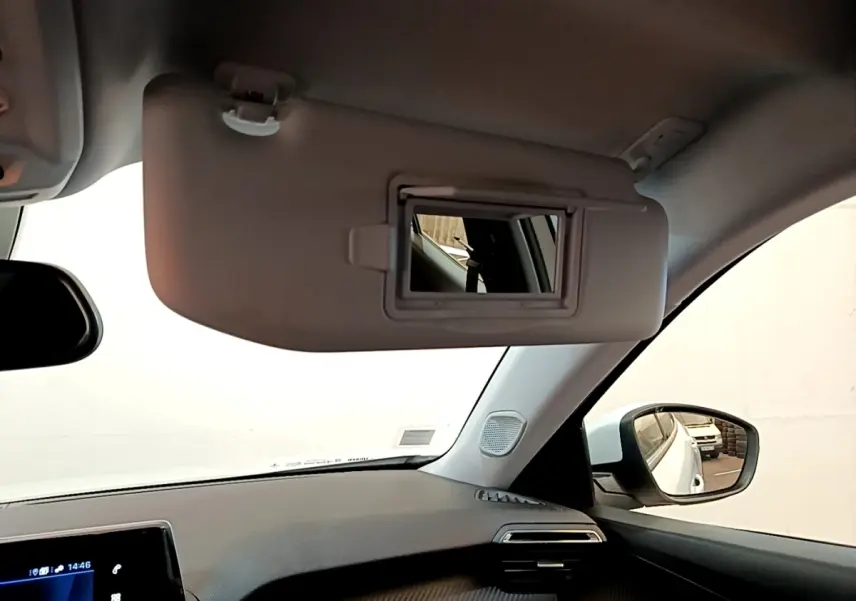 Vue intérieure côté passager du Peugeot 2008 blanc, avec pare-soleil déplié et miroir intégré visible.