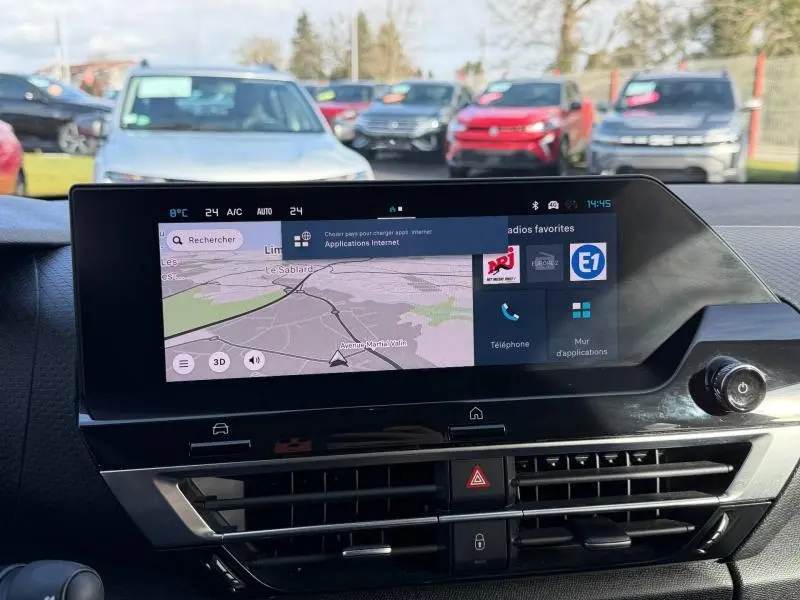 Écran tactile central du tableau de bord d'une Citroën C4 2024 gris, affichant la navigation et les applications connectées.