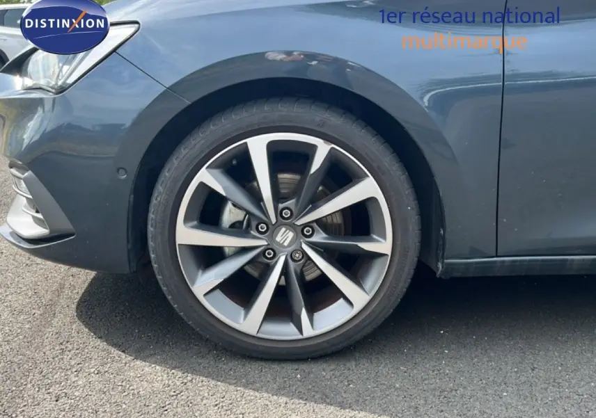 Gros plan sur la roue avant gauche d'une SEAT LEON ST gris magnétique métal avec jante alliage distinctive.