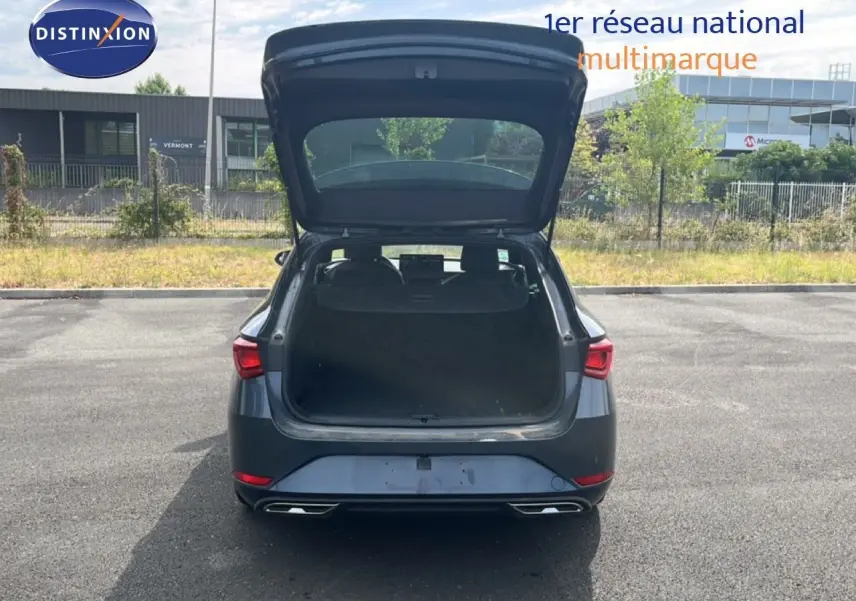 Vue arrière d'une SEAT LEON ST gris magnétique métal 2025 avec coffre ouvert sur un parking extérieur.