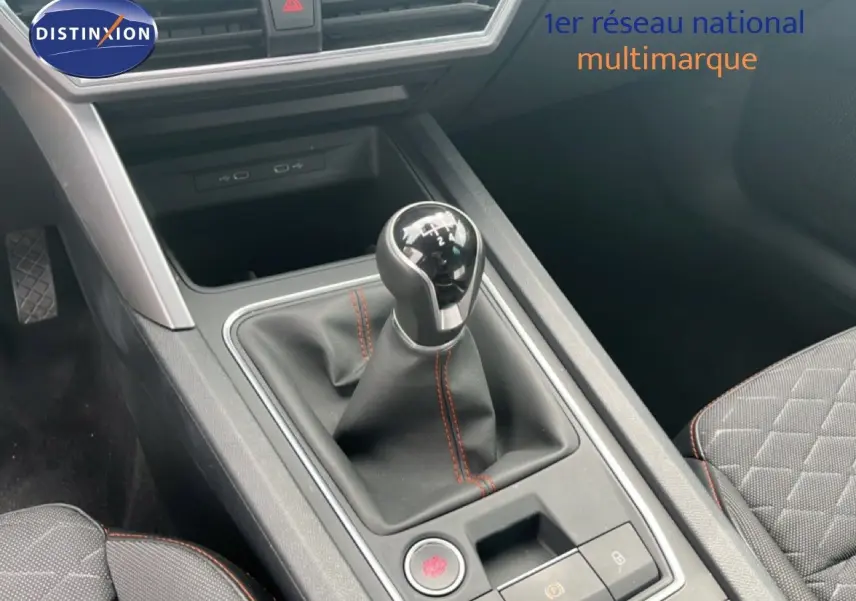 Le levier de vitesses manuel avec surpiqûres rouges dans l'habitacle gris noir du SEAT LEON ST 2025.