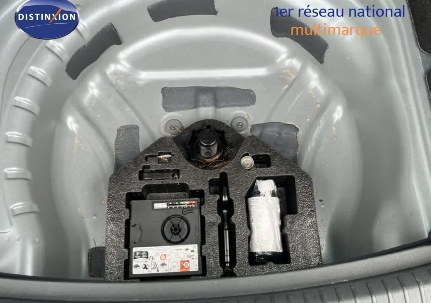 Vue plongeante sur le coffre ouvert d'une SEAT LEON ST 2025, montrant la roue de secours et les outils intégrés.