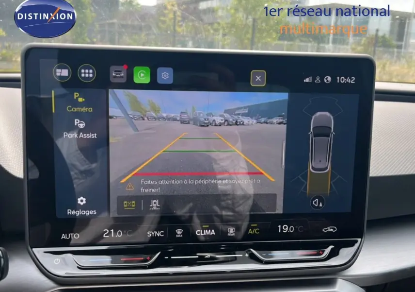 Écran tactile intérieur montrant la caméra de recul du SEAT LEON ST gris magnétique, avec affichage des aides au stationnement.