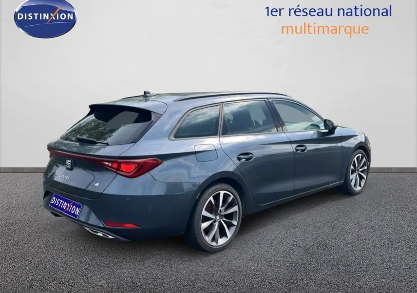 SEAT Leon ST gris magnétique métal vue 3/4 arrière droit, jantes alliage et feux arrière LED distinctifs.