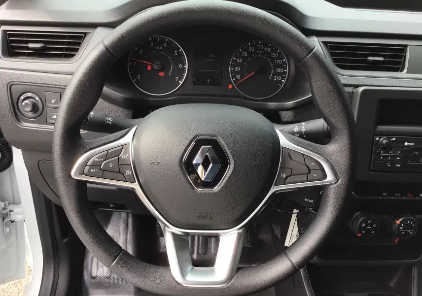 Vue rapprochée du volant noir du Renault Express Van blanc 2024, avec tableau de bord et commandes visibles.