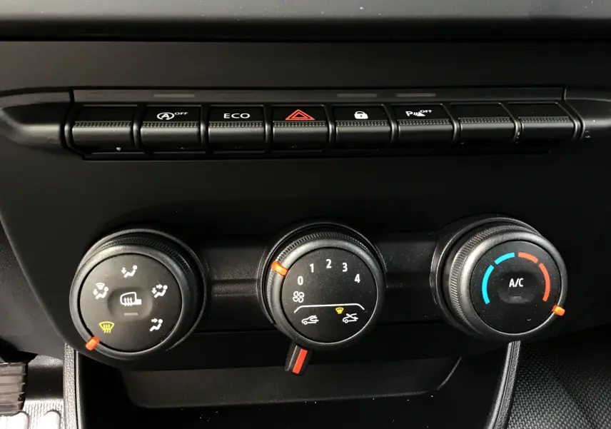 Gros plan sur les commandes de climatisation et les boutons de fonction du tableau de bord du Renault Express Van blanc 2024.