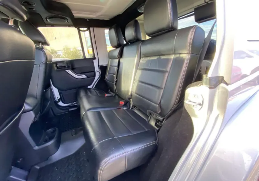 Vue intérieure arrière montrant les sièges en cuir noir du Jeep Wrangler gris clair 2012 version Unlimited.