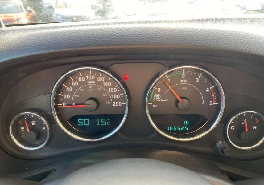 Tableau de bord du Jeep Wrangler 2012 montrant les compteurs de vitesse, régime, carburant et température moteur.