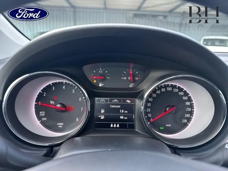 Tableau de bord de Ford vu de face, avec compte-tours, compteur de vitesse et écran multifonction affichant la consommation.