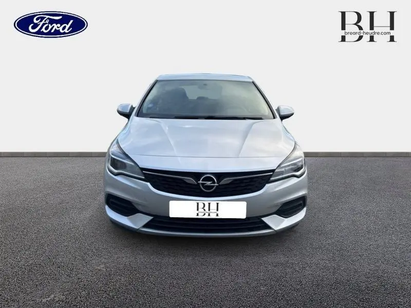 Vue de face d'une Opel Astra gris minéral 2020 avec calandre noire et phares profilés.