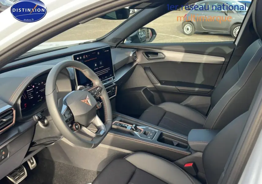 Vue intérieure côté conducteur du CUPRA Formentor blanc Nevada, mettant en valeur le volant cuir multifonction et l'écran tactile central.