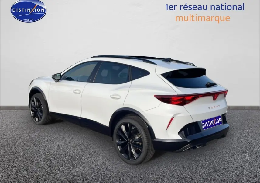 Vue 3/4 arrière droite d'un CUPRA Formentor blanc Nevada avec jantes noires et toit ouvrant panoramique.