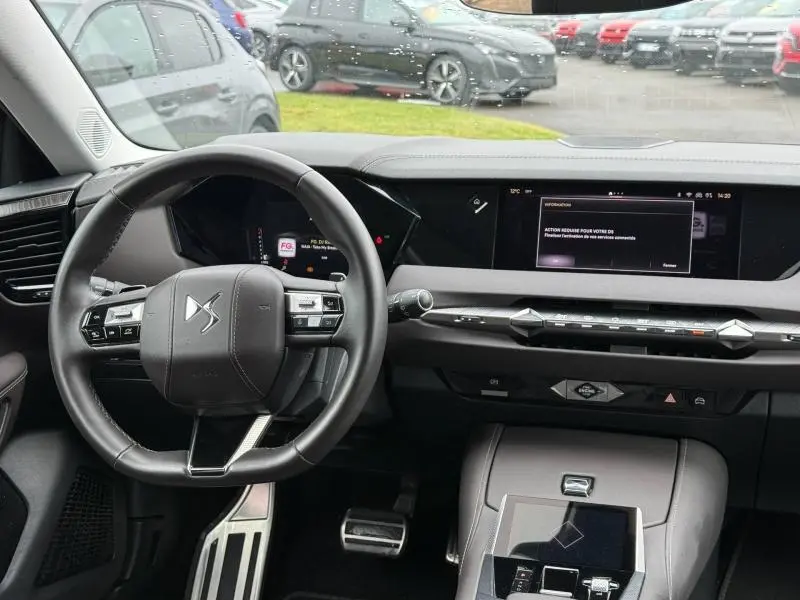 Vue intérieure du poste de conduite du DS4 2023 PureTech 130ch Opéra, avec tableau de bord numérique et volant multifonction noir.