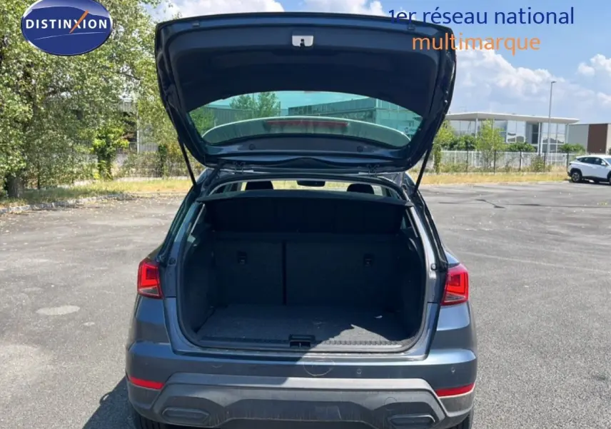 Vue arrière d'un SEAT Arona gris Magnetic Metal avec coffre ouvert et toit blanc visible en extérieur.