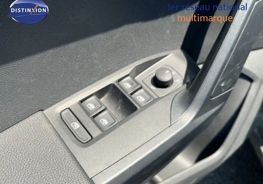 Gros plan sur les commandes des vitres et des rétroviseurs côté conducteur du SEAT Arona gris Magnetic 2025.