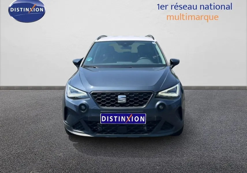 Vue frontale d'un SEAT Arona gris Magnetic Metal avec toit blanc, calandre noire et feux LED allumés.