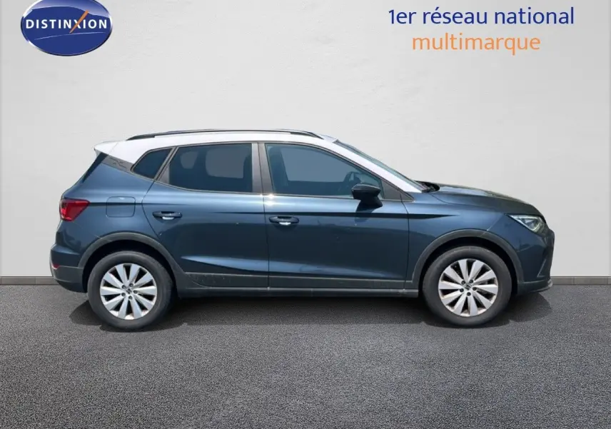 Profil droit d'un SEAT Arona 2025 gris Magnetic avec toit blanc, roues alliage et lignes dynamiques visibles.