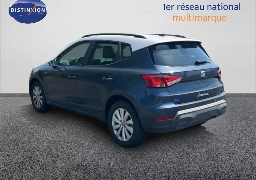 Vue 3/4 arrière droite d’un SEAT Arona gris foncé avec toit blanc, sur fond neutre en extérieur.