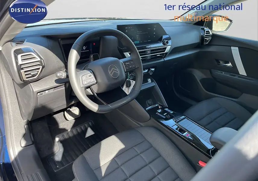 Vue intérieure côté conducteur de la Citroën C4 Hybrid 145ch avec tableau de bord moderne et sellerie tissu noir.