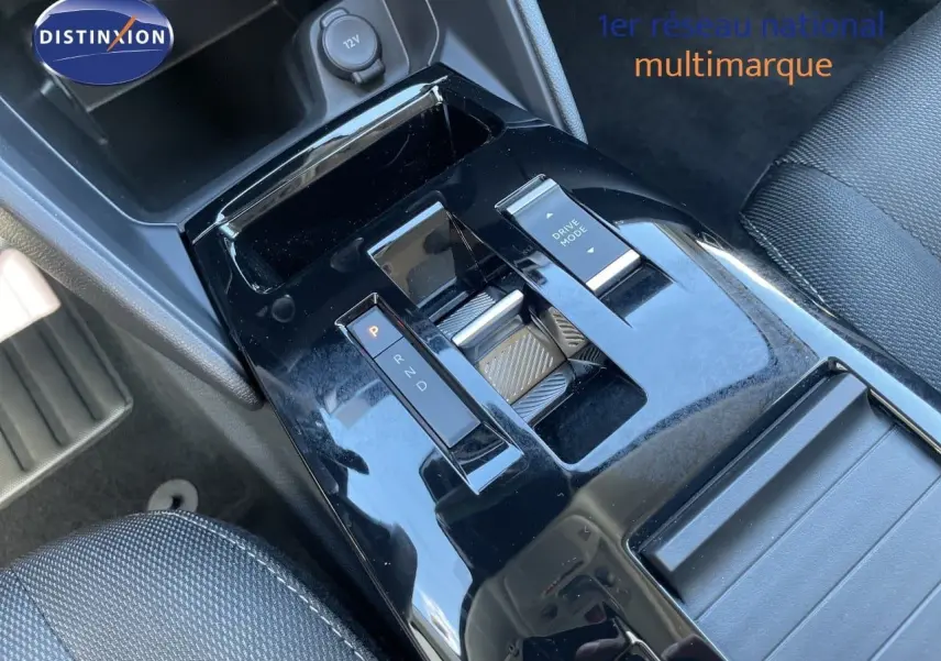 Gros plan sur la console centrale noire brillante de la Citroën C4 Hybrid 145ch avec levier de vitesses et bouton Drive Mode.