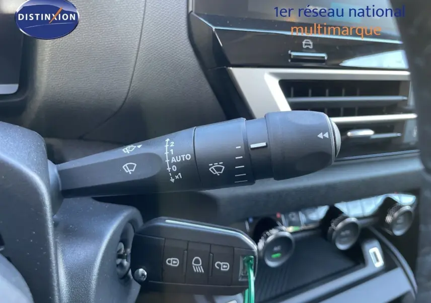 Gros plan sur la commande d’essuie-glace et la clé insérée dans le contacteur d’une Citroën C4 hybride, intérieur noir.