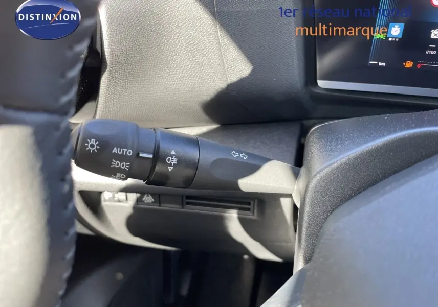 Gros plan sur la manette de commande des phares et clignotants à gauche du volant dans l’habitacle d’une Citroën C4 hybride.