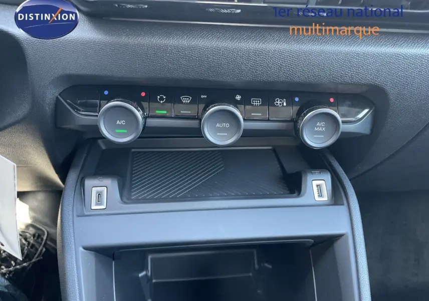 Vue rapprochée de la console centrale de la Citroën C4 Hybrid 145ch, avec commandes de climatisation et ports USB.