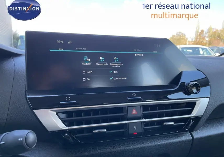 Écran tactile central et commandes de climatisation du tableau de bord d'une Citroën C4 Hybrid bleu Eclipse Metal, vue intérieure.