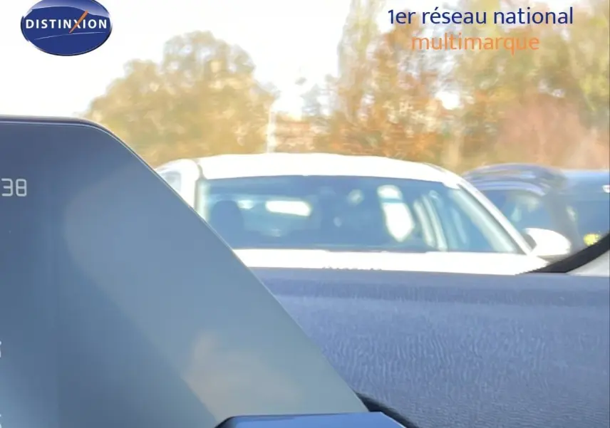 Vue intérieure depuis le tableau de bord d’une Citroën C4 Hybrid bleu eclipse métal, avec pare-brise et voitures en arrière-plan.