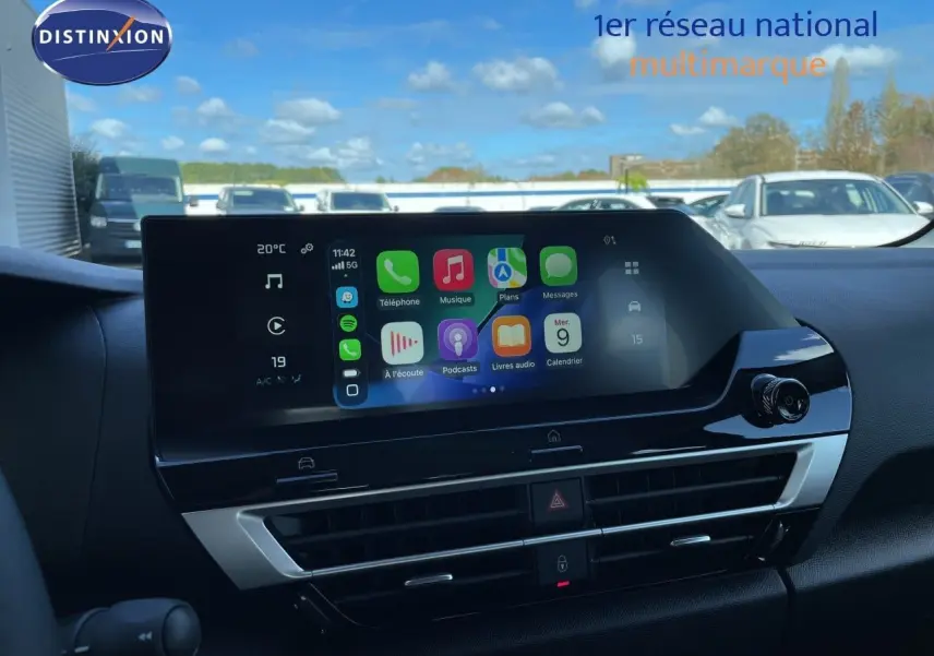 Écran tactile central affichant Apple CarPlay, tableau de bord noir intérieur d'une Citroën C4 hybride 2026.