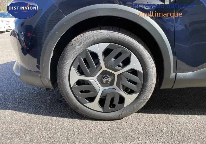 Gros plan sur la roue avant droite d'une Citroën C4 bleu Eclipse Metal, mettant en valeur la jante au design moderne.