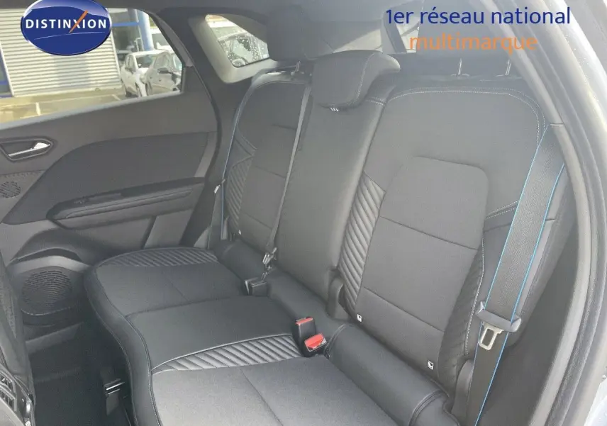 Vue intérieure sur les sièges arrière noirs avec surpiqûres bleues du Renault Symbioz gris Rafale 2024.