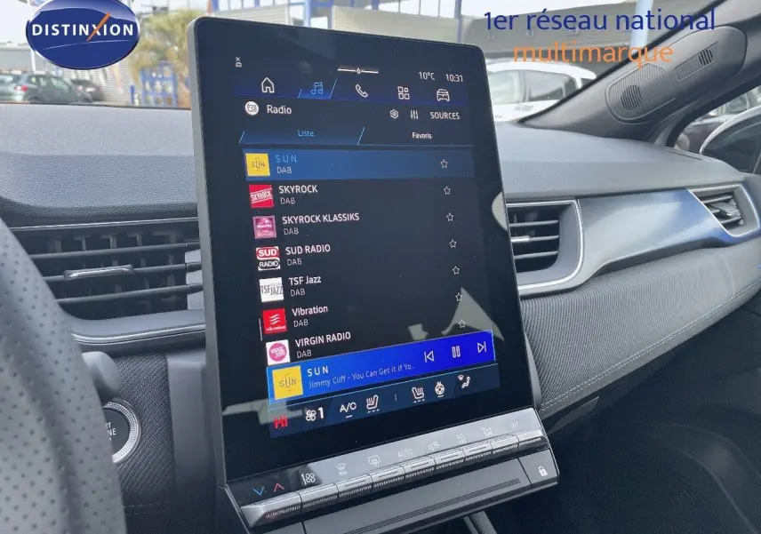 Vue intérieure centrée sur l'écran tactile vertical du tableau de bord du Renault Symbioz gris Rafale, avec commandes climatisation visibles.