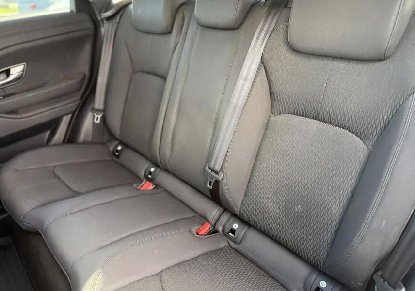 Vue intérieure sur les sièges arrière gris foncé du Range Rover Evoque 2017, montrant les ceintures et fixations ISOFIX.