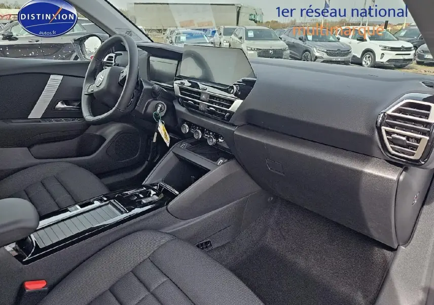 Intérieur noir de la Citroën C4 1.2 hybride 136 plus 2025, vue côté passager avec tableau de bord moderne et écran tactile central.