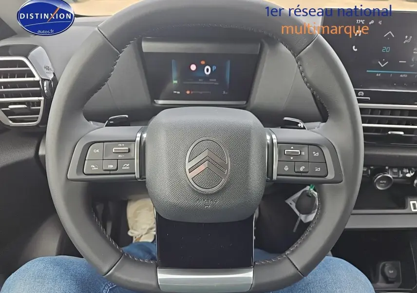 Vue centrée sur le volant cuir noir de la Citroën C4 1.2 hybride 136 plus avec tableau de bord numérique.