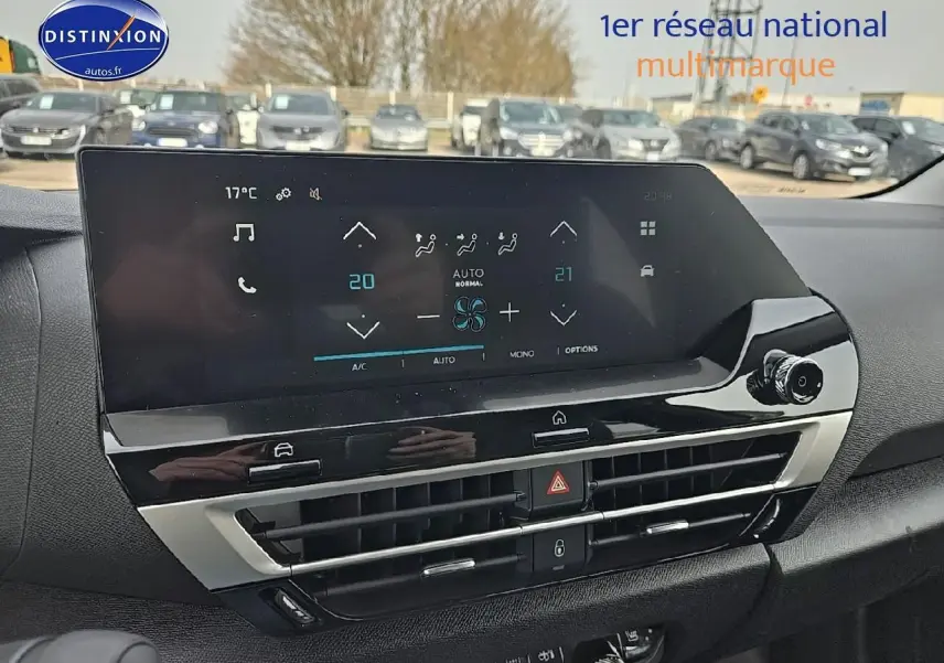 Écran tactile et aérateurs centraux du tableau de bord de la Citroën C4 blanche, vue intérieure frontale.