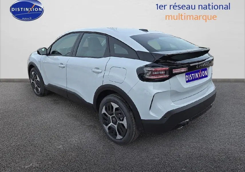 Vue 3/4 arrière droite d'une Citroën C4 blanche Okenite avec jantes 18 pouces et bande noire arrière brillante