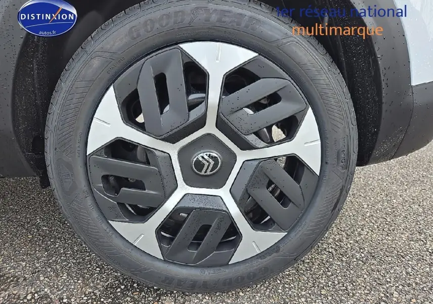 Gros plan sur la roue avant droite de la Citroën C4 blanche Okenite avec jante 18 pouces Aerotech noire et argentée.